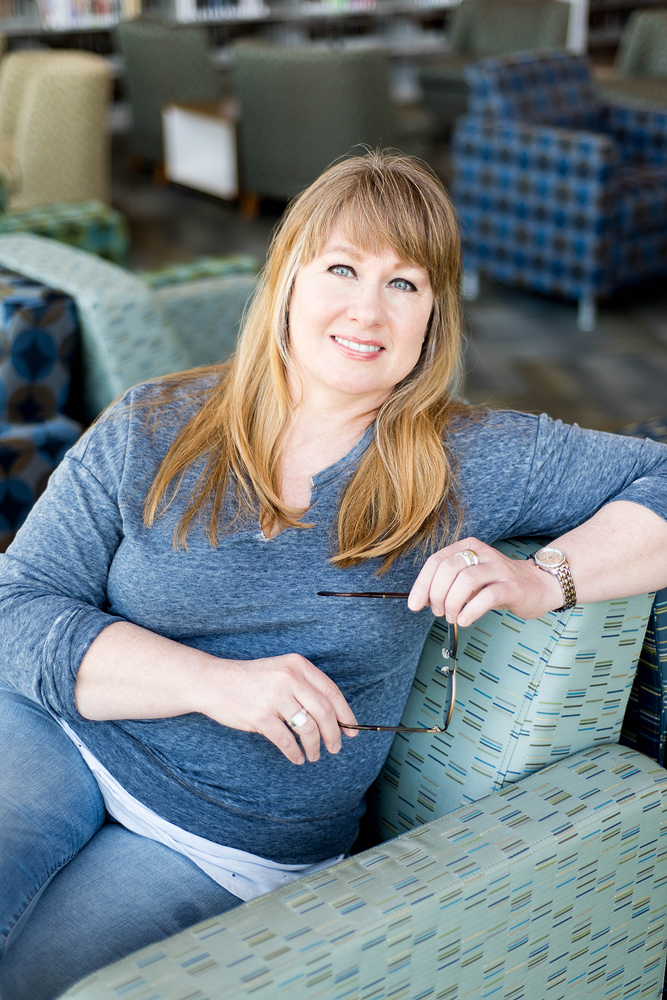 Paige Huskey relaxing in a sofa chair.
